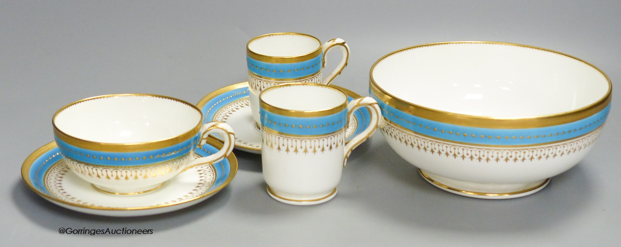 A Minton coffee cup, teacup and saucer with turquoise and gold jewelled band under a gold acid etched border, a matching coffee cup and saucer and a bowl